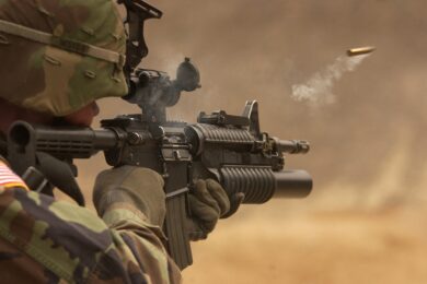 A soldier with a weapon in desert warfare